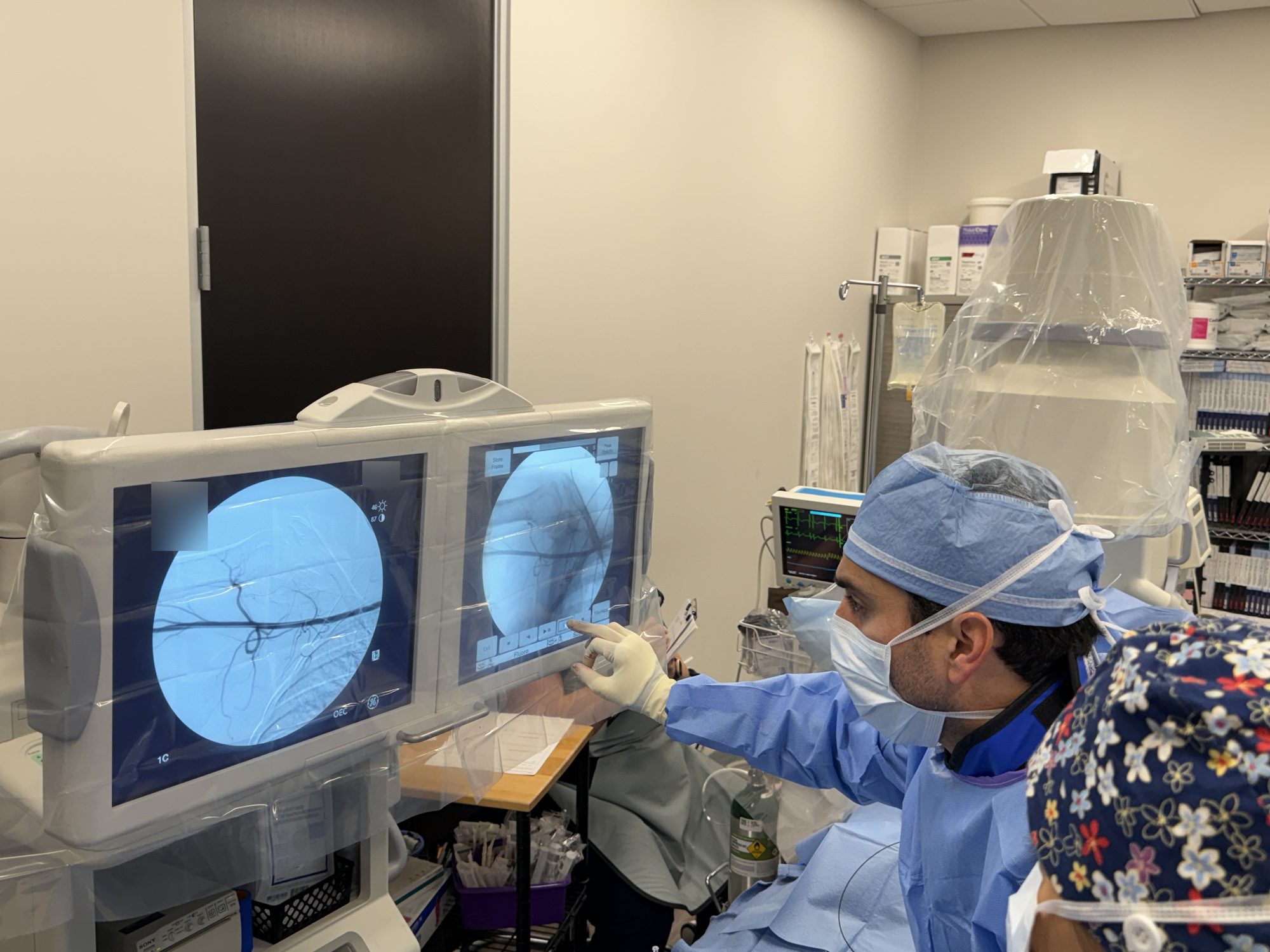 An ARV Centers interventional radiologist reviewing the shoulder angiogram on screen during a shoulder artery embolization