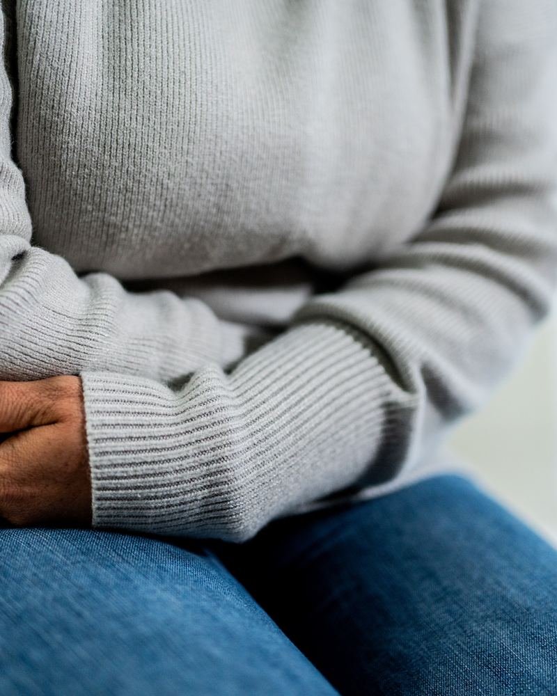 A woman holding her lower abdomen in pain