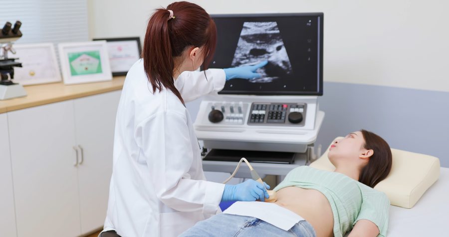 A woman lying flat on her back having a pelvic ultrasound
