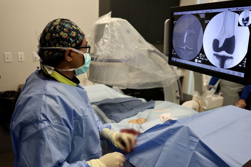 Dr. Arthur Joseph performing a genicular artery embolization, with the knee angiogram on screen
