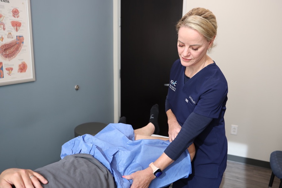 Dr. Lisa Persyn examining a patient&rsquo;s hip in our clinic