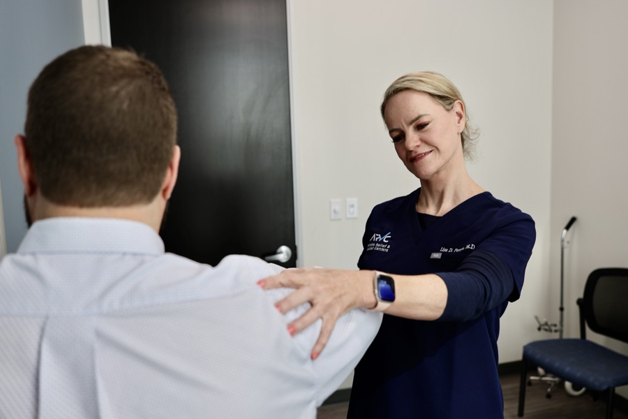 Dr. Lisa Persyn examining a patient&rsquo;s shoulder, testing its range of motion